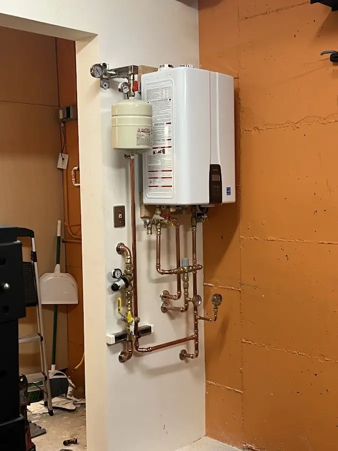 Plumbing technician inspecting water heater connections in Cambridge